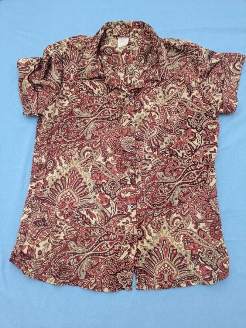 Whimsical Paisley Y2K Short Sleeve Button Down Blouse (Category: Blouses) located in Bocaue. Submitted by _agentorange (Listing ID 1468184175, Image 1). Description: - Brand: Shapes - Size: Small - Design: All-over intricate, y2k, paisley print in maroon, red, and cream - Details: Collared neckline, front button-down closure, and single left chest pocket - Fabric: Lightweight satin material, machine wash cold - Origin: Made in the Philippines, Se