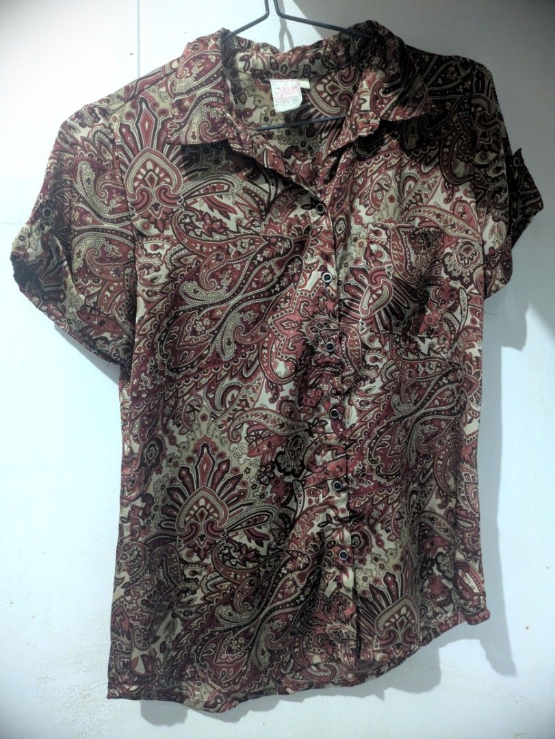 Whimsical Paisley Y2K Short Sleeve Button Down Blouse (Category: Blouses) located in Bocaue. Submitted by _agentorange (Listing ID 1468184175, Image 2). Description: - Brand: Shapes - Size: Small - Design: All-over intricate, y2k, paisley print in maroon, red, and cream - Details: Collared neckline, front button-down closure, and single left chest pocket - Fabric: Lightweight satin material, machine wash cold - Origin: Made in the Philippines, Se