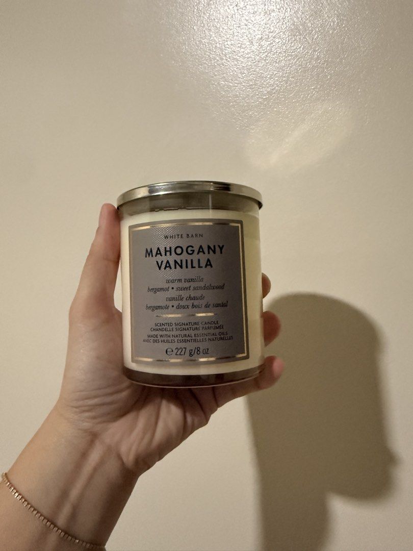 White Barn Mahogany Vanilla Single Wick Candle (Category: Home Fragrance) located in Mandaluyong City. Submitted by riz_040521 (Listing ID 1468076722, Image 1). Description: - Brand: White Barn (Bath & Body Works) - Scent: Mahogany Vanilla (Warm vanilla, fresh bergamot, sweet sandalwood) - Size: 8 oz / 227g (Single Wick) - Wax: Natural essential oils blend - Condition: Brand new, unlit, clean wax surface - Inclusion: Original silver metal lid wit