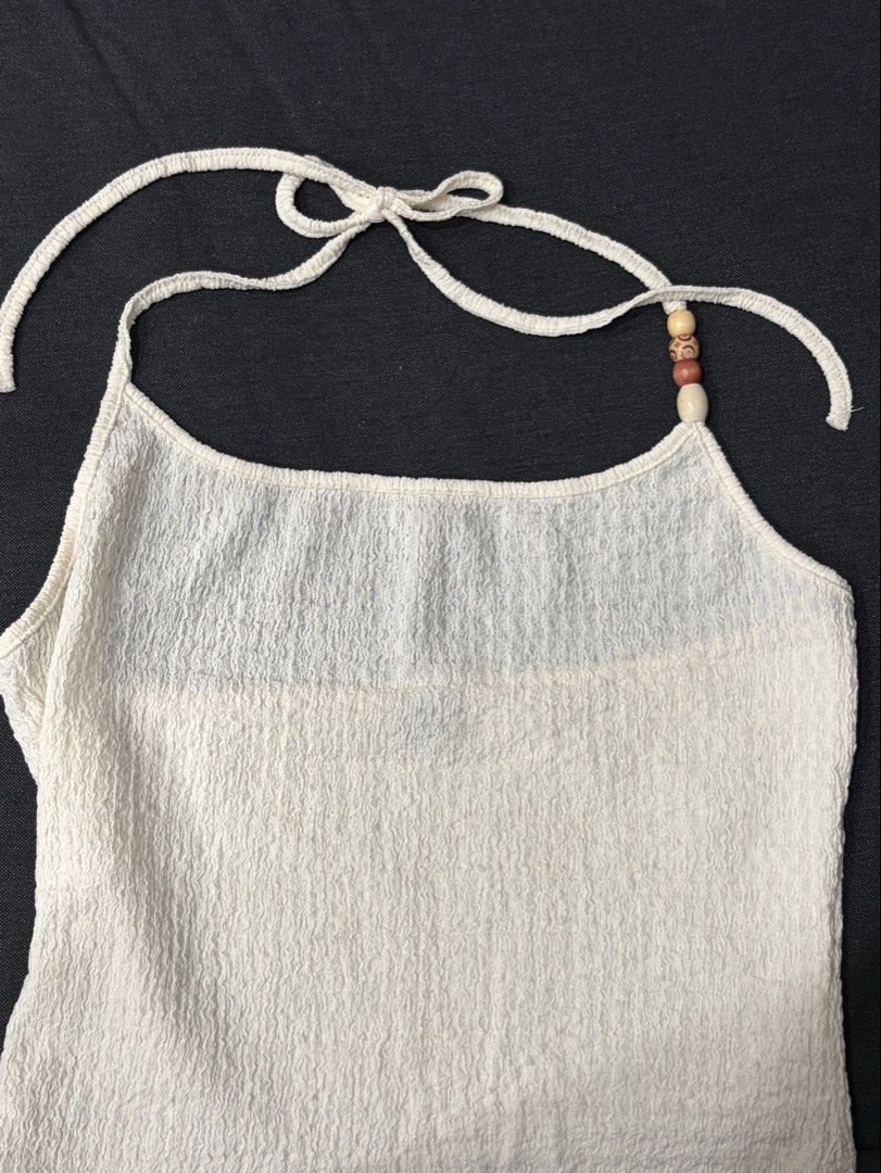 White crinkle halter neck tank top with beads (Category: Sleeveless) located in Manila. Submitted by cpaa.aaa (Listing ID 1468134068, Image 2). Description: White Halter neck tank top with square neckline Crinkled texture with patterned beads on the strap .