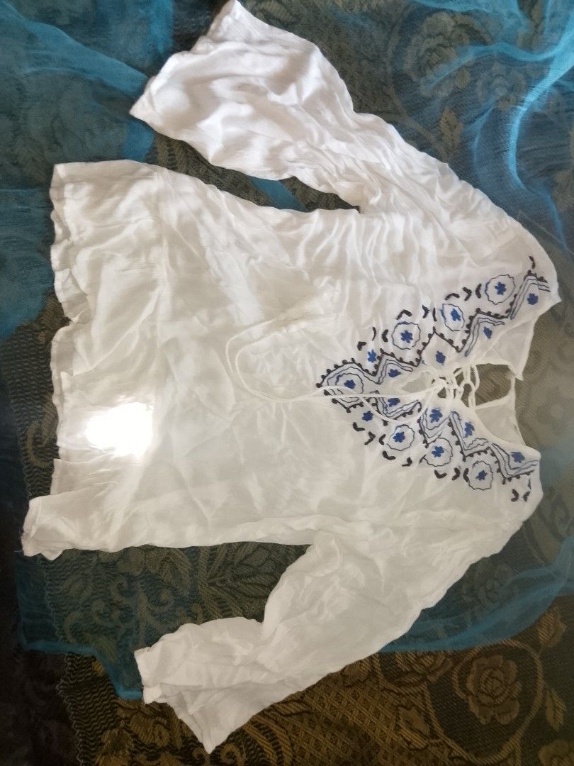 White embroided lace up boho blouse (Category: Longsleeves) located in Adams. Submitted by yelri555 (Listing ID 1468117559, Image 1). Description: TRUE LOVE White Boho Blouse - Size: Small to Medium (flowy) - White gauze cotton, blue embroidery - Lace-up neckline with tassels - Long sleeves, comfy for beach / school / daily - Condition: Good, no damage, no sign of use. needs ironing lang RFS: Declutter, nbu from package Loc: Narvacan.