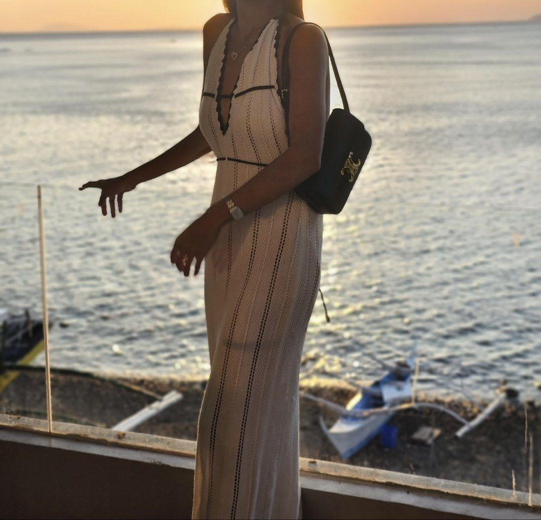 White Knit Halter Maxi Dress (Category: Dresses) located in Makati City. Submitted by jianciee (Listing ID 1468149272, Image 2). Description: - Style: White knit maxi dress with halter neck and deep plunging V-cut - Details: Contrast dark piping on bust and waistline with vertical ribbed texture - Fit: Long, form-fitting silhouette - Occasion: Ideal for vacations, beach dinners, or warm weather - Condition: Worn once for a photoshoot, immaculate 