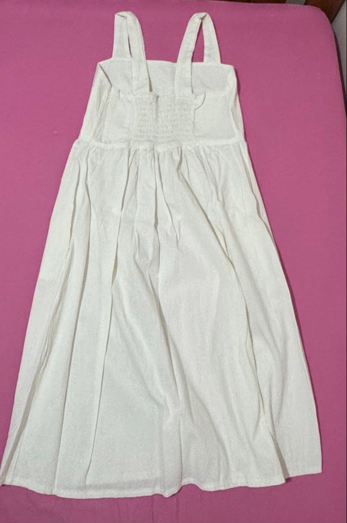 White Midi Dress (Category: Dresses) located in San Fernando. Submitted by declotter (Listing ID 1468074026, Image 2). Description: - Style: Casual plain white midi dress - Design: Sleeveless with thick tank straps and straight neckline - Fit: Smocked elastic back panel for extra stretch and easy wear - Silhouette: Gathered waist with a relaxed A-line skirt - Fabric: Lightweight and breathable - Perfect for: Everyday wear or sunny days out.