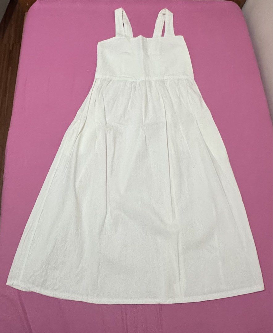 White Midi Dress (Category: Dresses) located in San Fernando. Submitted by declotter (Listing ID 1468074026, Image 1). Description: - Style: Casual plain white midi dress - Design: Sleeveless with thick tank straps and straight neckline - Fit: Smocked elastic back panel for extra stretch and easy wear - Silhouette: Gathered waist with a relaxed A-line skirt - Fabric: Lightweight and breathable - Perfect for: Everyday wear or sunny days out.