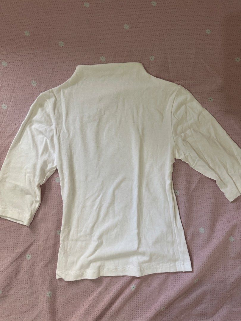 White Mock Neck Slim Fit Top (Category: Sleeveless) located in Lipa City. Submitted by chiechums (Listing ID 1468106129, Image 2). Description: - Color: White - Style: Mock neck with half-length sleeves - Fit: Fitted cut with soft, stretchy fabric - Versatility: Easy to style with shorts, jeans, or skirts - Condition: Brand new / Excellent quality - Perfect for daily wear and casual layering.