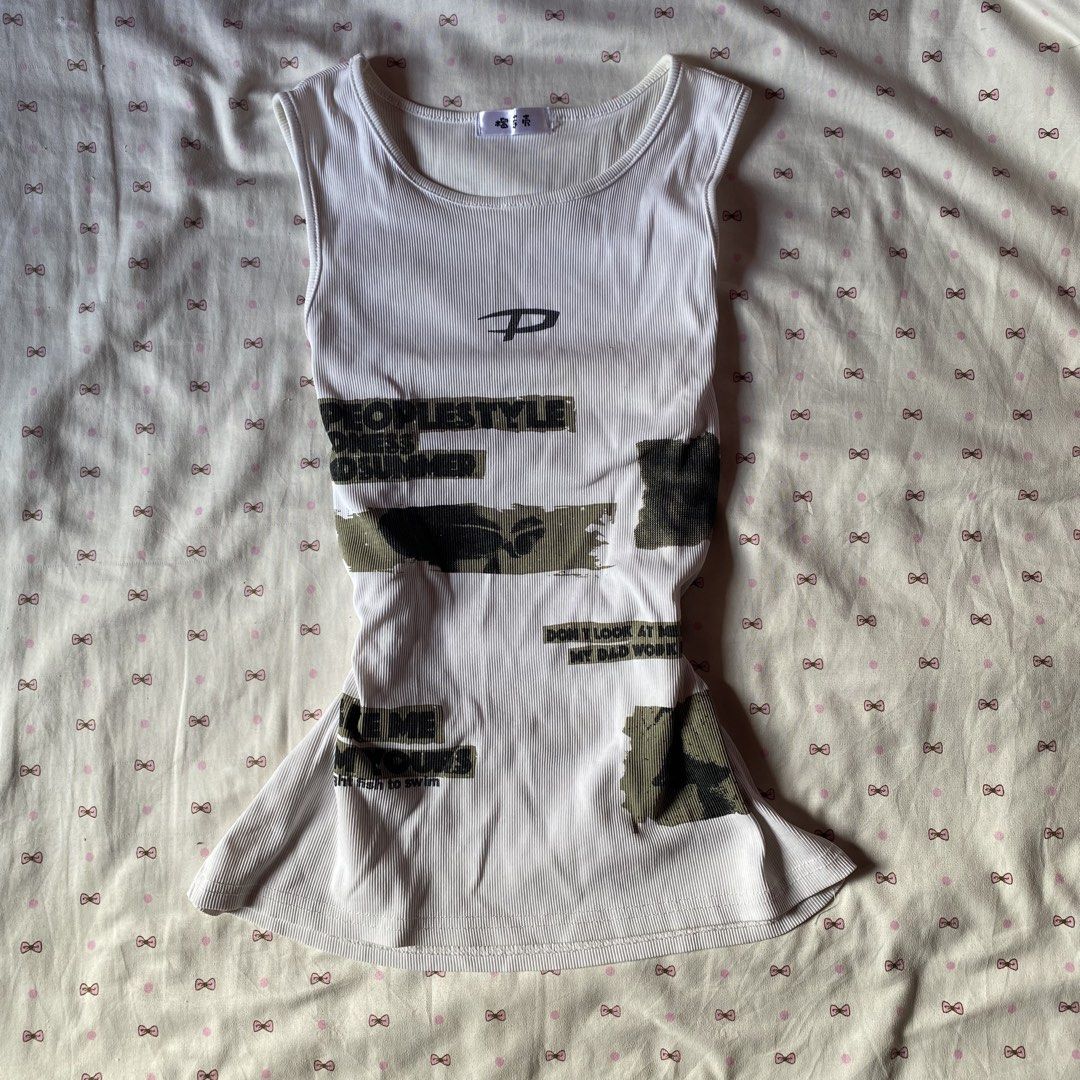 White ribbed graphic tank top with text print (Category: Sleeveless) located in Santiago. Submitted by dear_darlingdoll (Listing ID 1468127803, Image 1). Description: White ribbed tank top with graphic text prints and distressed patches. Scoop neckline and sleeveless cut. Fitted style with a slight flare at the bottom hem. Brand tag attached at the inner collar. Material has good stretch..