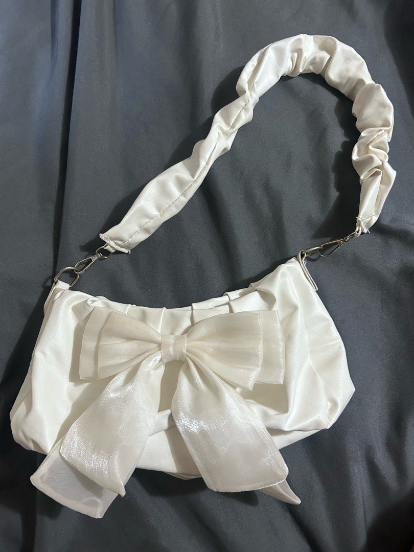 White Ribbon Scrunchie Handle Shoulder Bag (Category: Shoulder Bags) located in Manila. Submitted by thevintagebow (Listing ID 1468235179, Image 1). Description: Cute, feminine, and super budget-friendly! 🤍 Price: ₱200 php Details: Pre-loved / Used condition (as-is) Style: Ruffled strap with ribbon detail Send a message to claim now! 📩.