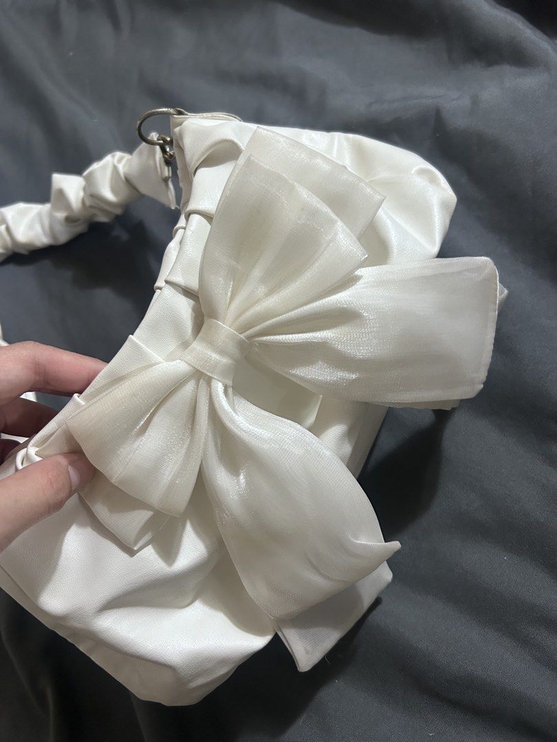 White Ribbon Scrunchie Handle Shoulder Bag (Category: Shoulder Bags) located in Manila. Submitted by thevintagebow (Listing ID 1468235179, Image 2). Description: Cute, feminine, and super budget-friendly! 🤍 Price: ₱200 php Details: Pre-loved / Used condition (as-is) Style: Ruffled strap with ribbon detail Send a message to claim now! 📩.