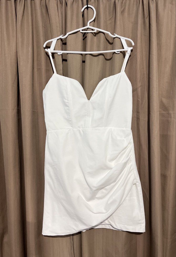 White Spaghetti Strap Ruched Bodycon Mini Dress (Category: Dresses) located in Cainta. Submitted by periwinkle.ph (Listing ID 1468187159, Image 1). Description: - Color: Clean solid white - Neckline: Sweetheart neckline with thin spaghetti straps - Fit: Fitted bodice with vertical seaming for a flattering silhouette - Details: Soft side ruching and trendy asymmetrical wrap hem - Occasion: Ideal for parties, dates, and nights out - Condition: Bran