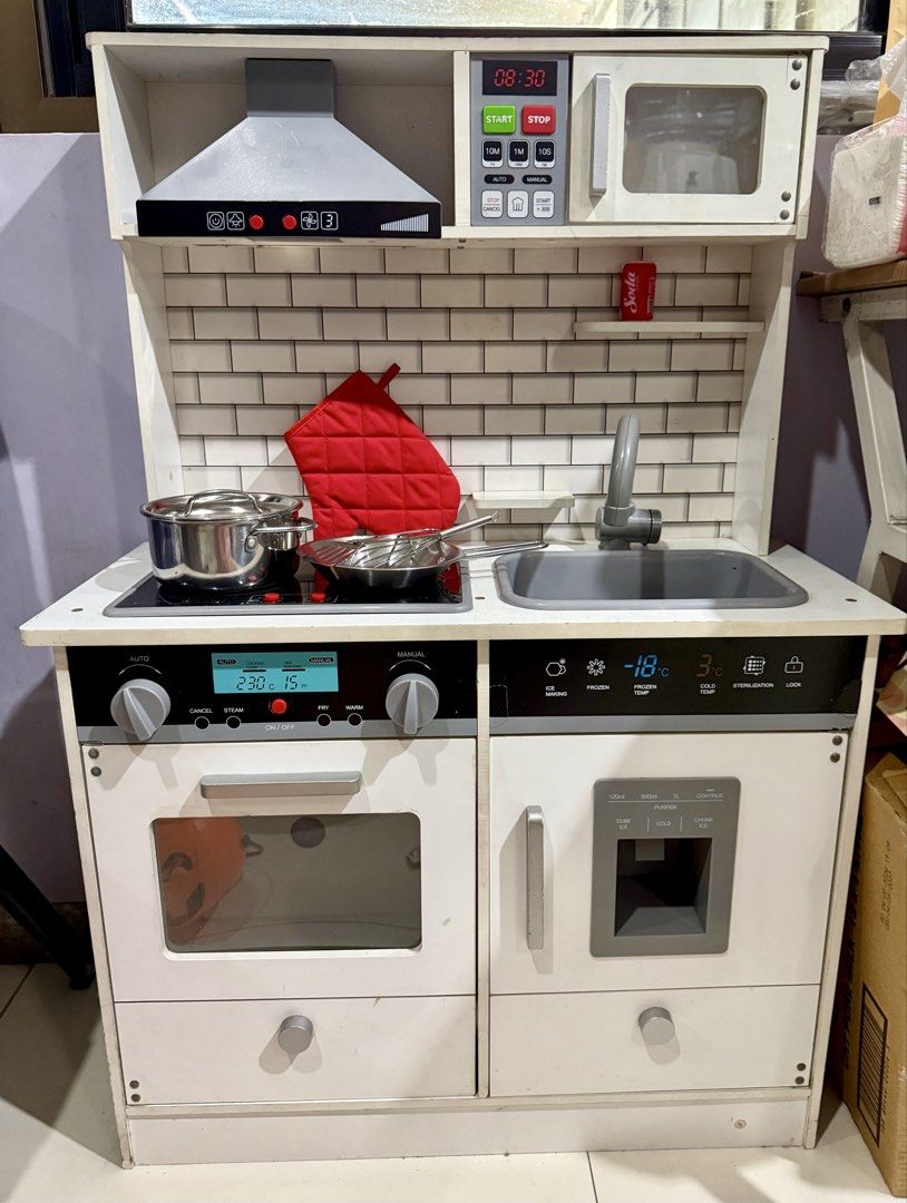 Wooden Play Kitchen Set with Accessories (Category: Kids Toys) located in Manila. Submitted by ika.musume (Listing ID 1468073479, Image 1). Description: - Large wooden toy kitchen designed for imaginative play - Features a stove top, oven, microwave, sink, and pretend refrigerator with ice dispenser - Interactive elements: turning control knobs and light-up digital panels - Includes bonus accessories: stainless steel pot, pan, whisk, and a red ov
