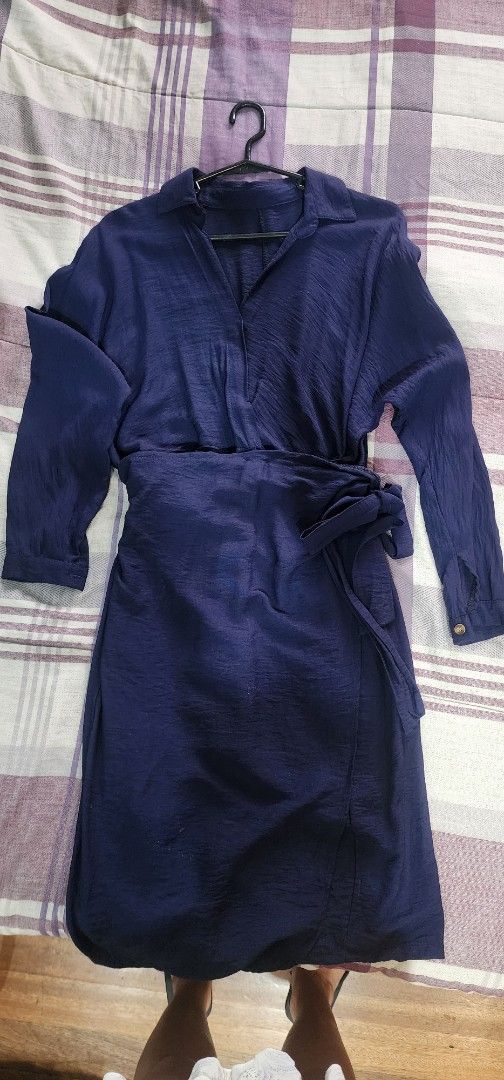 Wrap dress Zara (Category: Dresses) located in Quezon City. Submitted by 24pink.lotus (Listing ID 1468111849, Image 2). Description: - Color: Navy blue - Style: Midi length wrap dress with long sleeves and classic collar - Fit: Adjustable wrap-style waist tie - Fabric: Lightweight textured material with a slight slit at the hem - Condition: Like new, worn only a few times and properly stored in wardrobe.