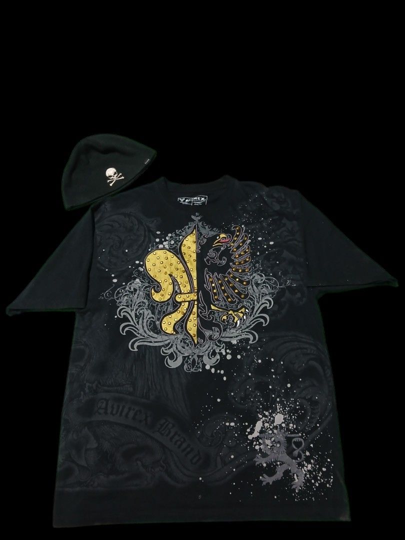 Y2k Avirex studed grunge tee (Category: Tshirts & Polo Shirts ) located in San Jose. Submitted by garments17 (Listing ID 1468201904, Image 1). Description: - Brand: Avirex - Set includes: Black t-shirt and matching beanie - Style: Heavy gothic rock - Shirt details: Studded front graphic (gold fleur-de-lis and eagle), all-over splatter print, and scrollwork - Beanie details: Features a small skull and crossbones patch - Condition: Excellent nego.