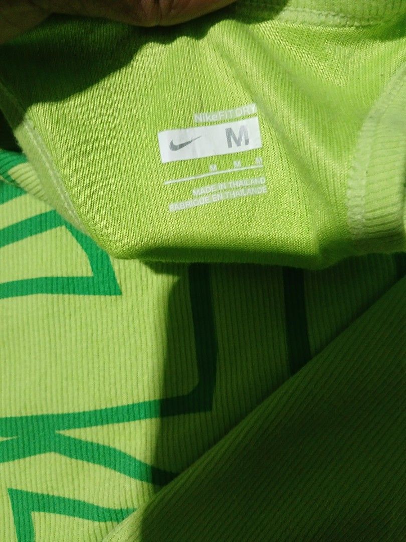 Y2k Nike tank tops (Category: Activewear) located in San Jose. Submitted by garments17 (Listing ID 1468202715, Image 3). Description: Green Nike tank top in size medium. Large graphic print reading JUST DO IT down the front. Small embroidered Nike swoosh logo near the bottom hem. Ribbed fabric texture throughout. Tag inside shows Nike Fit Dry and made in Thailand. Clean and ready to wear for workouts or casual days..