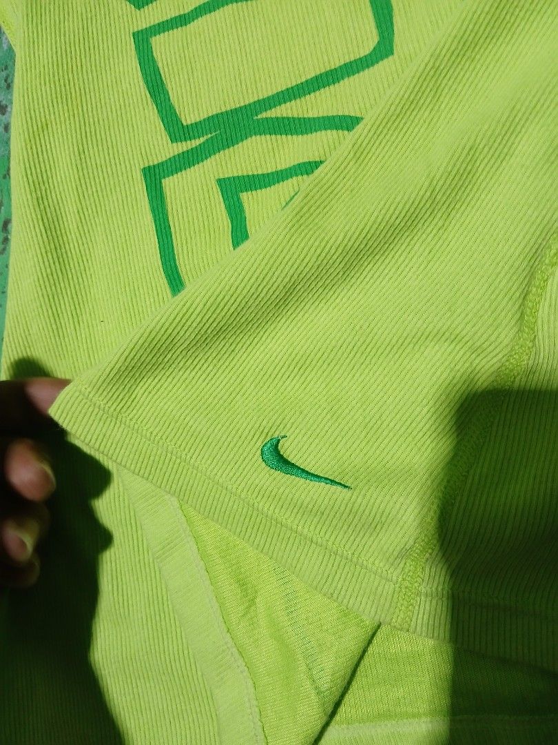 Y2k Nike tank tops (Category: Activewear) located in San Jose. Submitted by garments17 (Listing ID 1468202715, Image 2). Description: Green Nike tank top in size medium. Large graphic print reading JUST DO IT down the front. Small embroidered Nike swoosh logo near the bottom hem. Ribbed fabric texture throughout. Tag inside shows Nike Fit Dry and made in Thailand. Clean and ready to wear for workouts or casual days..