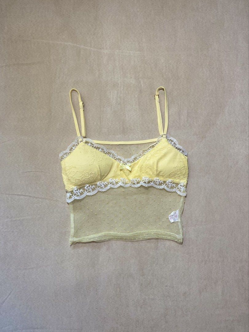 Yellow Lace Trim Dot Mesh Cami Top (Category: Sleeveless) located in Quezon City. Submitted by rosealison (Listing ID 1468127133, Image 2). Description: - Color: Butter yellow with white lace trim Size: Small - Design: Sheer mesh body with tiny polka dots and a cute center bow - Features: Adjustable spaghetti straps, unpadded soft cups - Condition: used twice with tag attached - Lightweight and sheer fabric.
