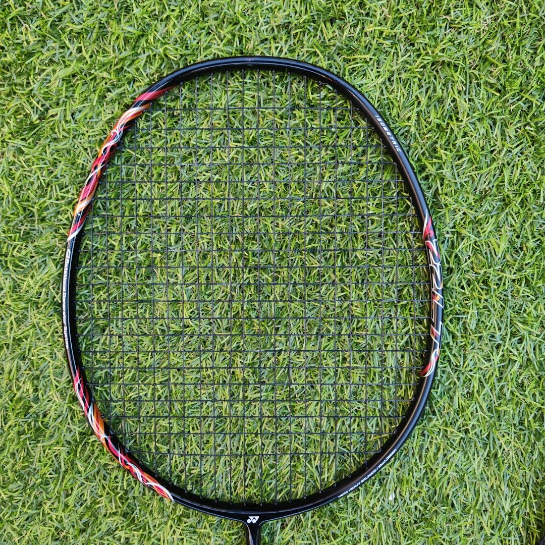 Astrox 22LT with Cover Case (Category: Racket and Ball Sports) located in Marikina City. Submitted by jonshop (Listing ID 1468140003, Image 2). Description: - Brand: Yonex - Colorway: Black frame with red and white accents - Handle: Wrapped in a bright yellow overgrip 420ex - Condition: String Yonex BG65 Black (29 tension) with one small scuff mark on the top of the frame - Inclusion: Comes with a black Yonex zip cover bag featuring white brandin
