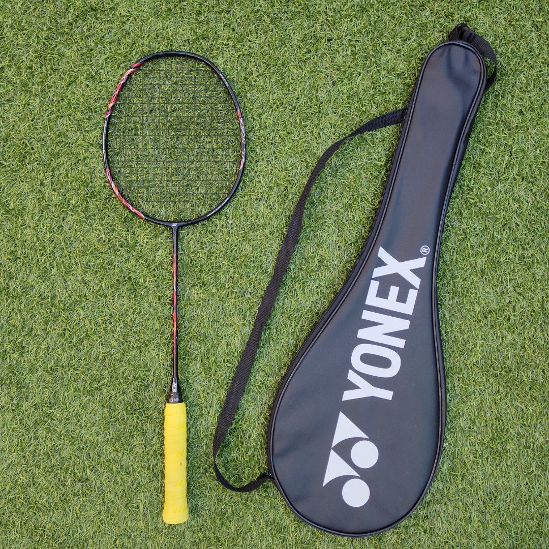 Astrox 22LT with Cover Case (Category: Racket and Ball Sports) located in Marikina City. Submitted by jonshop (Listing ID 1468140003, Image 1). Description: - Brand: Yonex - Colorway: Black frame with red and white accents - Handle: Wrapped in a bright yellow overgrip 420ex - Condition: String Yonex BG65 Black (29 tension) with one small scuff mark on the top of the frame - Inclusion: Comes with a black Yonex zip cover bag featuring white brandin