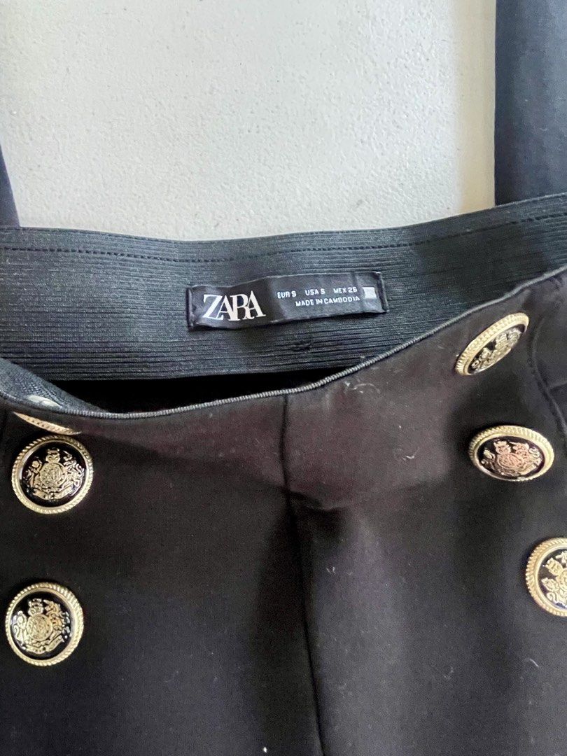 Zara Black Pants with Gold Buttons Size S (Category: Jeans) located in Manila. Submitted by tineferna08917 (Listing ID 1468099196, Image 3). Description: - Brand: Zara - Size: S (EUR S, MEX 26) - Color: Classic Black - Fit: High-waist with a comfortable elastic waistband in the back - Design: Statement gold crest buttons on each side and chic front seam details - Material: Stretchy, structured fabric - Origin: Made in Cambodia.