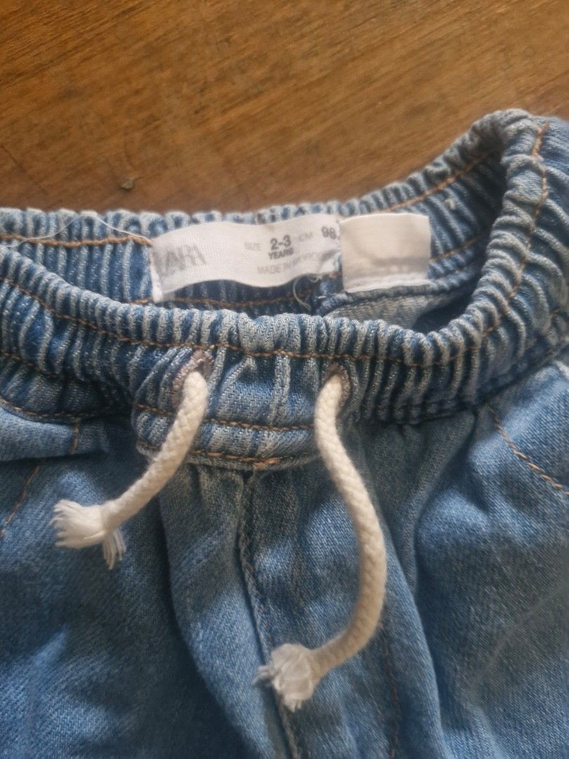 Zara Denim Jogger Pants Size 2-3 Years (Category: Babies & Kids Fashion) located in Cebu City. Submitted by minimi.cebu (Listing ID 1468083401, Image 2). Description: - Brand: Zara - Size: 2-3 years (98 cm) - Color: Light blue wash - Material: Soft and comfortable for toddlers - Waistband: Elastic with adjustable white drawstring - Cuffs: Elastic at the ankles - Pockets: Two functional side pockets - Style: Easy pull-on design.