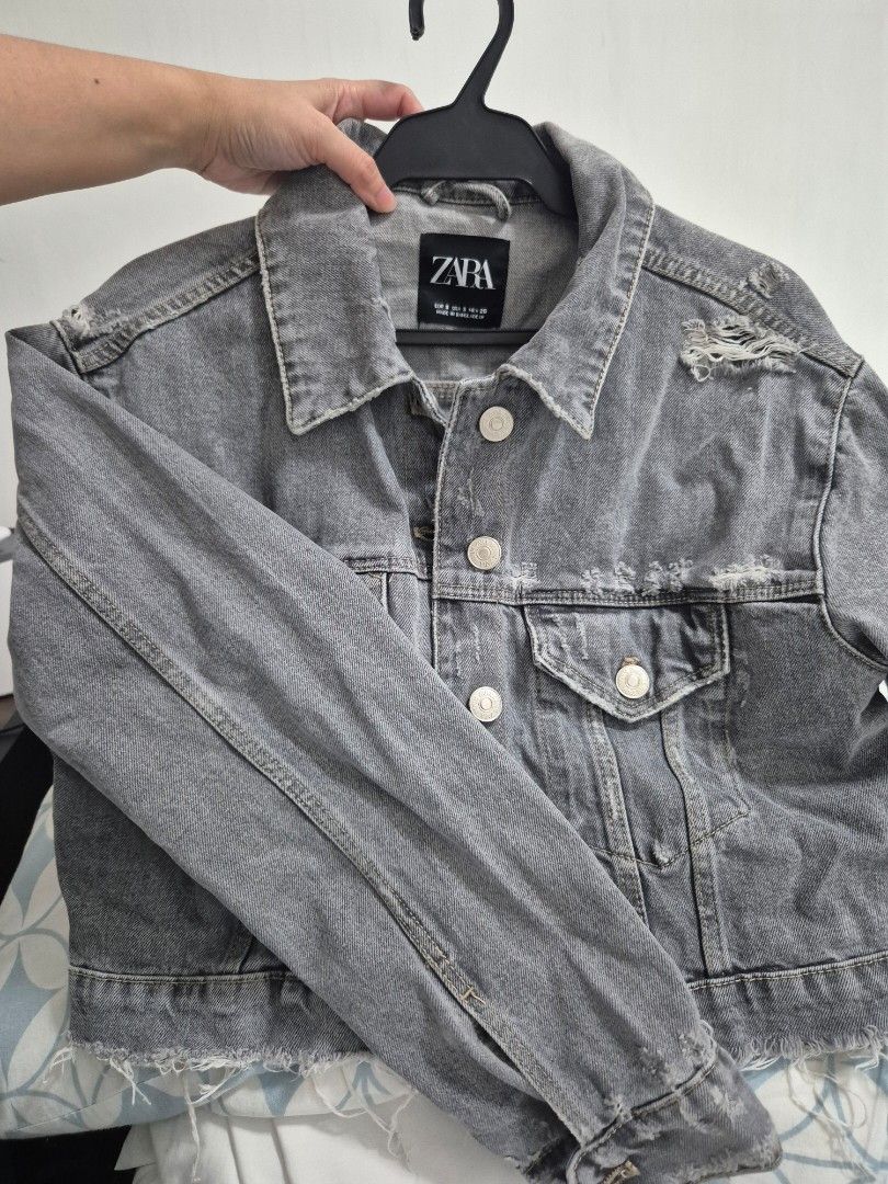 Zara Grey Distressed Crop Denim Jacket Size S (Category: Coats, Jackets and Outerwear) located in Quezon City. Submitted by 53888 (Listing ID 1468200090, Image 3). Description: - Brand: Zara - Color: Grey - Size: S (fits true to size) - Fit: Cropped with raw frayed hem - Details: Distressed accents near collar and shoulder - Features: Front button closure and chest pockets - Origin: Made in Bangladesh.