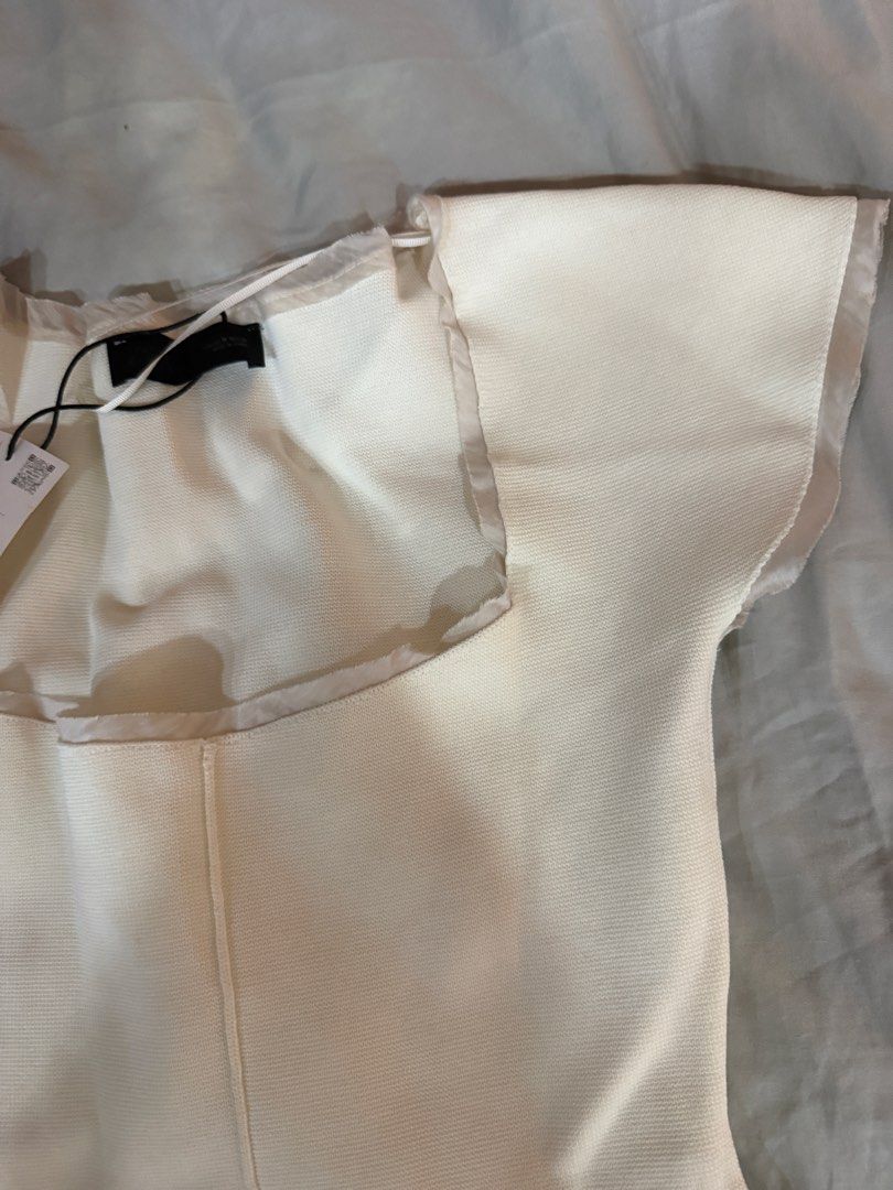 Zara Square Neck Knit Top White Size M (Category: Sleeveless) located in Pasig City. Submitted by atbp__ (Listing ID 1468111049, Image 3). Description: - Brand: Zara - Style: Knit top with square neckline and short cap sleeves - Color: Off-white - Size: Medium (M) - Condition: Brand new with original store tag attached - Details: Textured knit fabric with delicate trim along the collar, sleeves, and hem - Reason for selling: Wardrobe clearance.