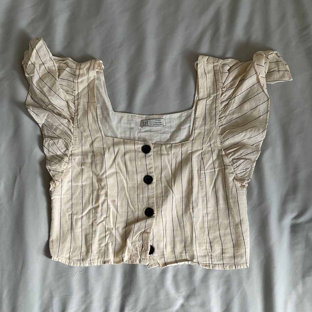 Zara Striped Square Neck Top (Category: Blouses) located in Quezon City. Submitted by declutter.chek (Listing ID 1468136233, Image 2). Description: - Brand: Zara TRF - Style: Cropped blouse with square neckline & short flutter ruffle sleeves - Design: Cream with thin black stripes and contrast black buttons - Material: Lightweight and comfortable fabric - Condition: Worn a few times, still in great shape.