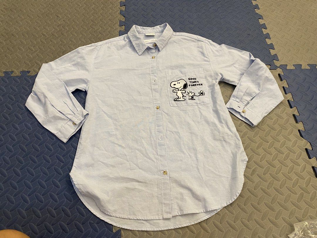 Zara x Peanuts Snoopy Long Sleeve Button Down Shirt (Category: Longsleeves) located in Santa Rosa. Submitted by hoardqueensdeclutter (Listing ID 1468198270, Image 2). Description: - Brand: Zara (Peanuts Collection) - Item: Light blue long sleeve button-down shirt - Design: Snoopy 'GOOD TIMES FOREVER' chest pocket graphic and huge Snoopy back print - Features: Standard collar, button cuffs, and curved hemline - Size: 13-14 years / 164 cm - Conditi