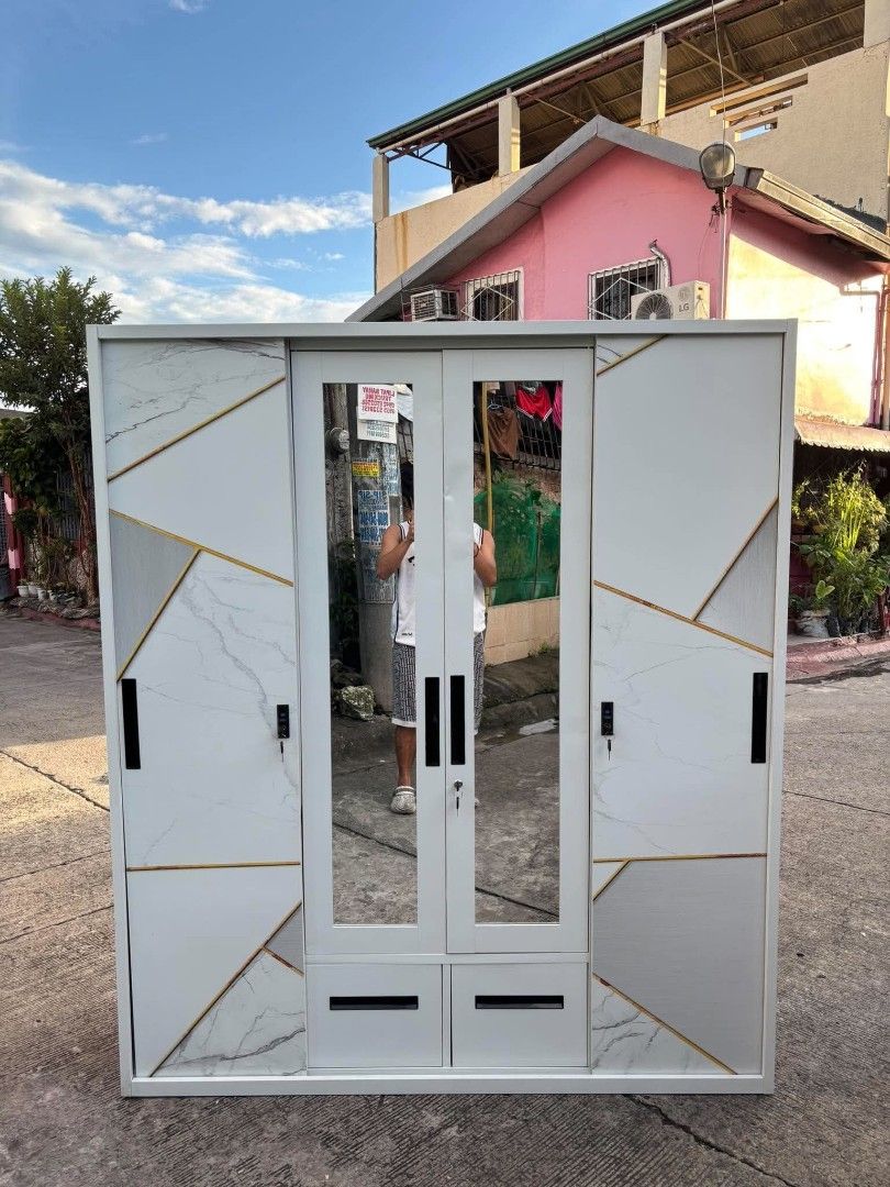 160cm Three-Door Cabinet with Marble Pattern and Mirrors (Category: Shelves, Cabinets & Racks) located in Manila. Submitted by ajimdolor012051 (Listing ID 1468326547, Image 2). Description: - Type: 4-door wardrobe with sliding doors - Design: Modern white marble finish with geometric gold lines - Features: 2 central mirrors, 2 bottom drawers, hanging rail, multiple shelves, and 1 lockable inner compartment - Material: Sturdy metal construction - 