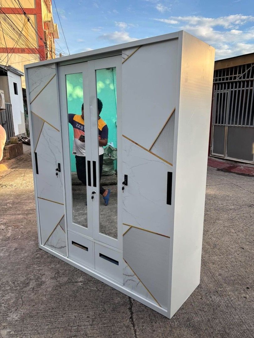160cm Three-Door Cabinet with Marble Pattern and Mirrors (Category: Shelves, Cabinets & Racks) located in Manila. Submitted by ajimdolor012051 (Listing ID 1468326547, Image 3). Description: - Type: 4-door wardrobe with sliding doors - Design: Modern white marble finish with geometric gold lines - Features: 2 central mirrors, 2 bottom drawers, hanging rail, multiple shelves, and 1 lockable inner compartment - Material: Sturdy metal construction - 