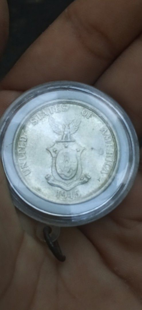 1945 Fifty Centavos commonwealth (Category: Currency) located in Daanbantayan. Submitted by mvs08_collectibles (Listing ID 1468323107, Image 2). Description: - Genuine 1945 US Administration Philippines fifty centavos coin - Obverse features Lady Manila beside a volcano with a hammer and anvil - Reverse displays the historical US-Philippines shield and eagle - Encased in a clear protective capsule with a convenient hanging loop - Ideal addition f