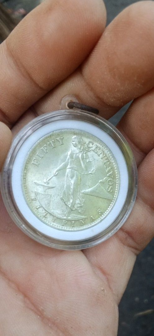 1945 Fifty Centavos commonwealth (Category: Currency) located in Daanbantayan. Submitted by mvs08_collectibles (Listing ID 1468323107, Image 1). Description: - Genuine 1945 US Administration Philippines fifty centavos coin - Obverse features Lady Manila beside a volcano with a hammer and anvil - Reverse displays the historical US-Philippines shield and eagle - Encased in a clear protective capsule with a convenient hanging loop - Ideal addition f