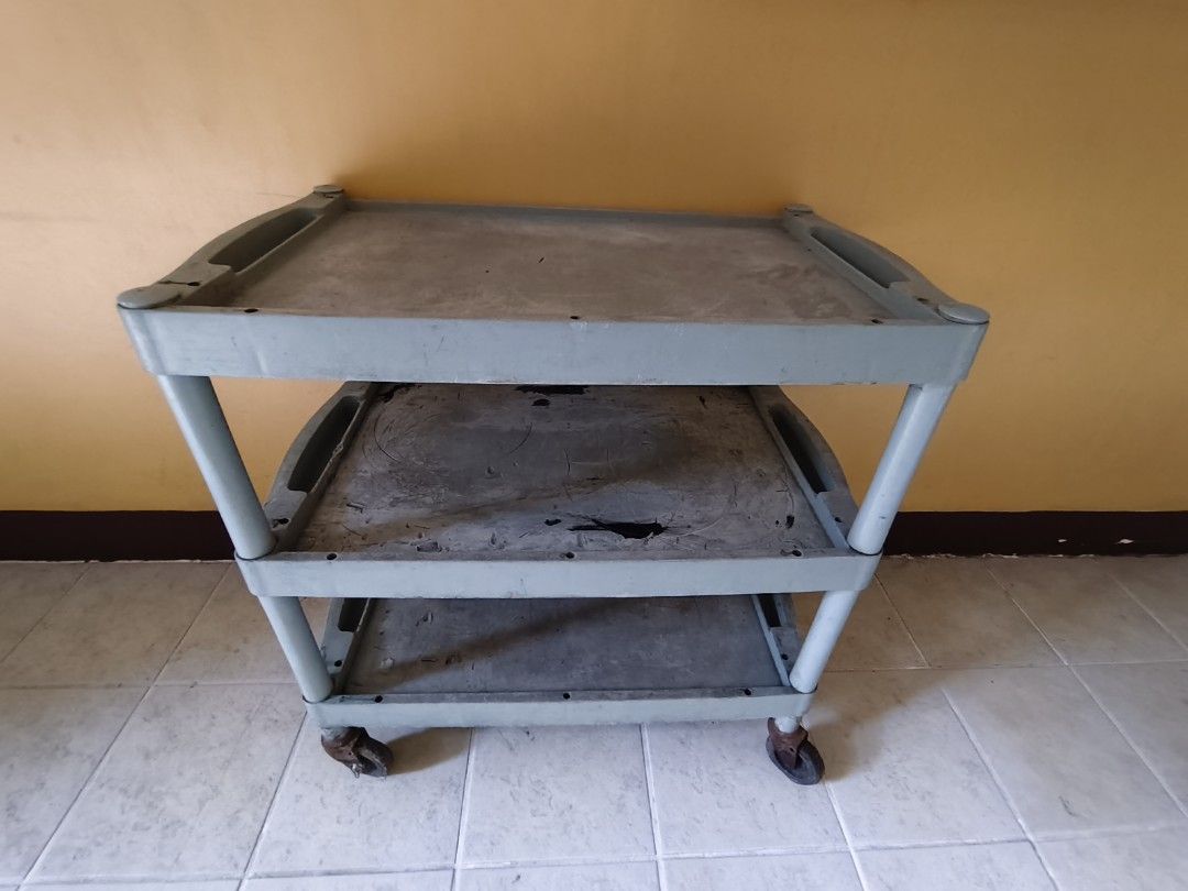 3-Tier Plastic Utility Cart with Wheels (Category: Storage Boxes & Baskets) located in Pasig City. Submitted by maming73 (Listing ID 1468305966, Image 2). Description: - Color: Grey - Material: Heavy-duty plastic with metal caster hardware - Design: 3 levels of storage with built-in top handles - Mobility: 4 smooth-rolling caster wheels for easy movement - Condition: Shows normal daily wear including surface scratches, scuffs, and visible rust on