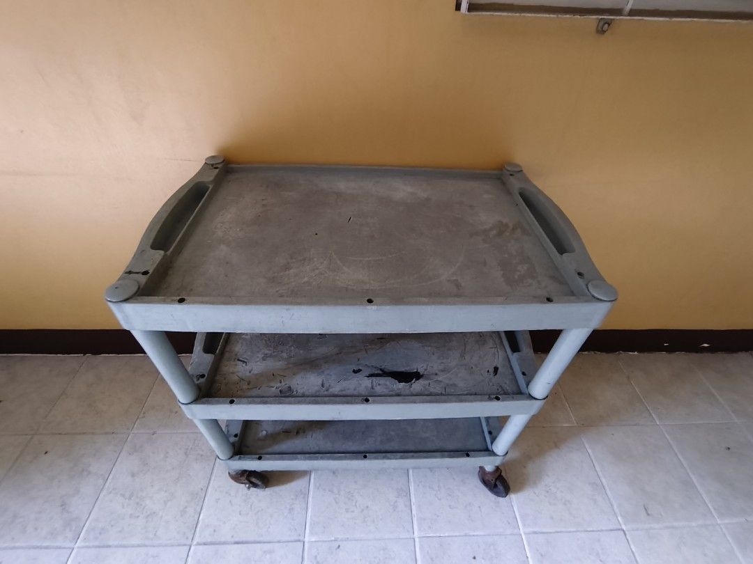3-Tier Plastic Utility Cart with Wheels (Category: Storage Boxes & Baskets) located in Pasig City. Submitted by maming73 (Listing ID 1468305966, Image 3). Description: - Color: Grey - Material: Heavy-duty plastic with metal caster hardware - Design: 3 levels of storage with built-in top handles - Mobility: 4 smooth-rolling caster wheels for easy movement - Condition: Shows normal daily wear including surface scratches, scuffs, and visible rust on