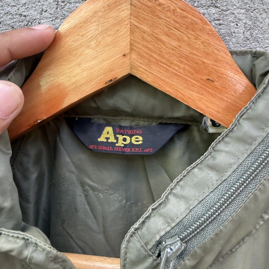 A Bathing Ape Ape General Track Jacket Olive (Category: Coats, Jackets and Outerwear) located in Caloocan City. Submitted by ayogorenia1002 (Listing ID 1468351398, Image 3). Description: - Brand: A Bathing Ape (BAPE) - Color: Olive green with white double sleeve stripes - Details: Full zip, high collar with unique zipper accent, Ape General chest logo - Pockets: Two zippered side pockets - Condition: Excellent / Pre-owned - Shipping: Fast ship na