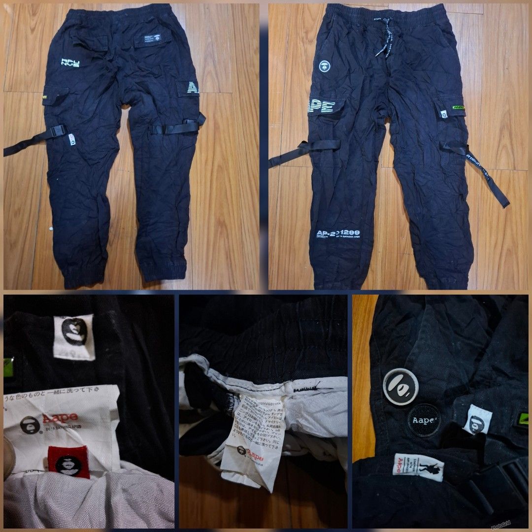Aape By A Bathing Ape Black Cargo Pants (Category: Joggers) located in Caloocan City. Submitted by ed5312124 (Listing ID 1468414981, Image 1). Description: Black cargo pants by Aape. Lots of pockets, straps, and printed graphics on the legs. Elastic waistband with drawstring and elastic cuffs at the ankles. Multiple branded tags and patches attached throughout. Standard fit streetwear style. Clean fabric, tags still attached inside..