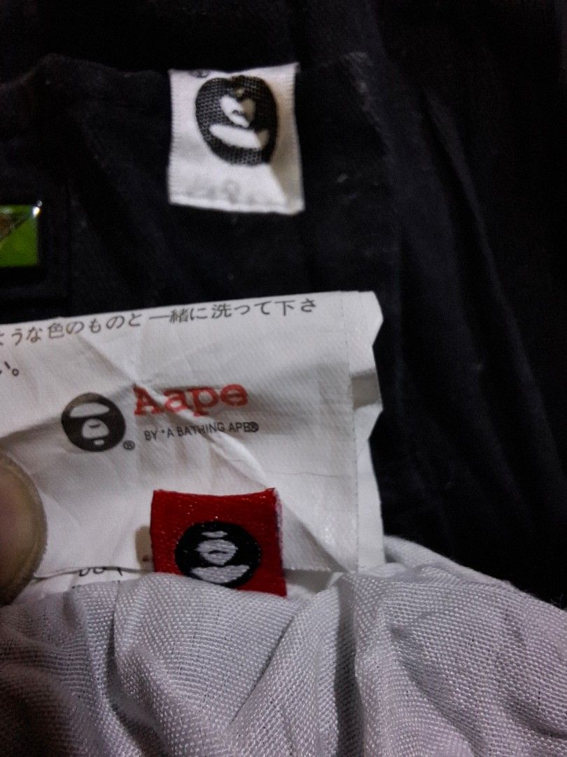 Aape By A Bathing Ape Black Cargo Pants (Category: Joggers) located in Caloocan City. Submitted by ed5312124 (Listing ID 1468414981, Image 2). Description: Black cargo pants by Aape. Lots of pockets, straps, and printed graphics on the legs. Elastic waistband with drawstring and elastic cuffs at the ankles. Multiple branded tags and patches attached throughout. Standard fit streetwear style. Clean fabric, tags still attached inside..