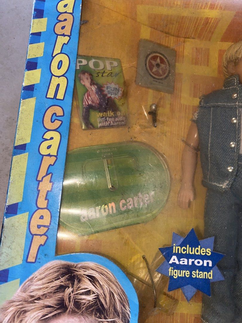 Aaron Carter Play Along Doll Figure in Box (Category: Figurines & Statues) located in Manila. Submitted by togekimiwa (Listing ID 1468345822, Image 3). Description: - Rare 2001 Aaron Carter collectible action figure by Play Along Toys - Outfit features a stylish denim vest over a white tank top and jeans - Includes bonus accessories: miniature pop star magazine, star sticker sheet, microphone pin, and green figure stand with printed signature - F