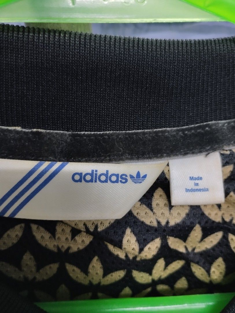 Adidas Black and Gold Track Jacket (Category: Coats, Jackets and Outerwear) located in Manila. Submitted by niggzreyno51476 (Listing ID 1468400312, Image 3). Description: - Brand: Adidas - Color: Black with gold details - Design: Classic 3-stripes on sleeves, small trefoil logo on chest, large embroidered trefoil logo on back - Lining: Patterned inner lining with repeating trefoil leaf print - Features: Zip-up front, side pockets, standard bomber