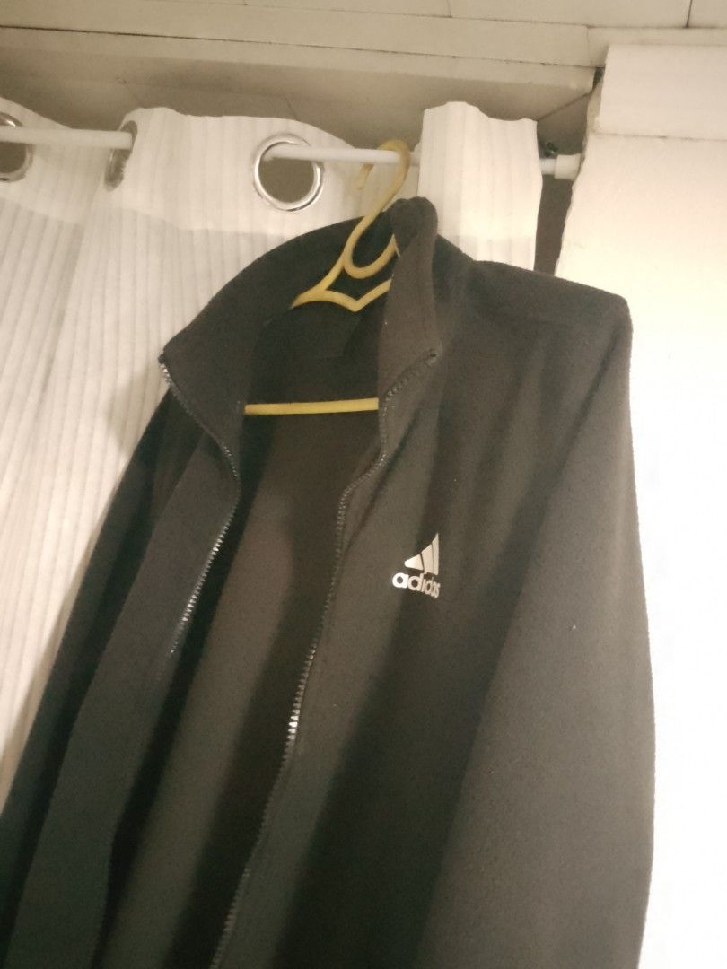 Adidas Black Fleece Zip-Up Jacket (Category: Coats, Jackets and Outerwear) located in Manila. Submitted by warmtiger.a2c491 (Listing ID 1468361228, Image 1). Description: - Brand: Adidas - Color: Black with white embroidered logo - Material: Warm and cozy fleece - Features: Full zip front, high collar, and adjustable drawstring hem with toggles - Condition: Excellent - Perfect for: Cool weather layering and casual wear - Shipping or meetups avail
