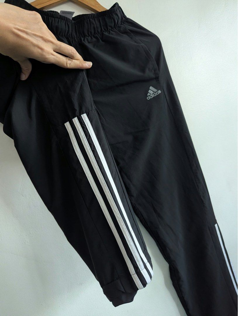 Adidas Black Track Pants with White Stripes (Category: Joggers) located in Quezon City. Submitted by thegoodkarmaph (Listing ID 1468325278, Image 2). Description: - Color: Classic Black with signature white three stripes - Material: Lightweight, breathable nylon/polyester blend - Features: Comfortable elastic waistband, convenient side pockets, and small silver Adidas logo - Versatility: Perfect for gym workouts, running, or casual everyday wear 