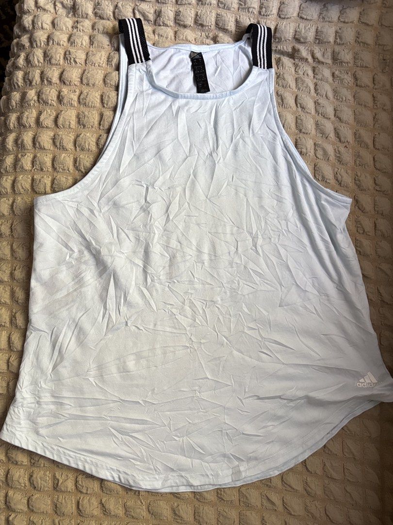 Adidas Sport Tank Top Light Blue (Category: Activewear) located in Batangas. Submitted by lilirosie (Listing ID 1468346241, Image 3). Description: - Brand: Adidas - Color: Light blue with black and white striped elastic straps - Size: S (tagged) - Material: Lightweight athletic fabric - Origin: Made in Indonesia - Design: High neck cut with logo printed near the bottom hem - Flaw: May sunog ng konti sa likod para lang sa hindi maselan.