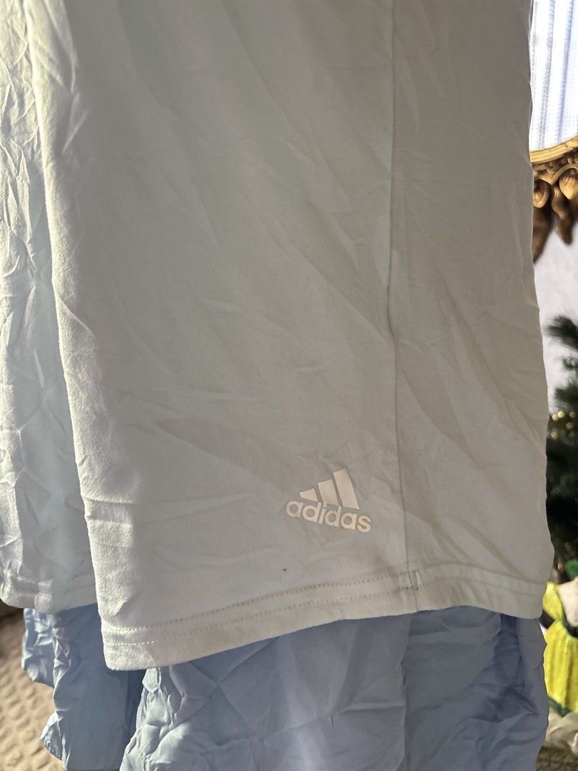Adidas Sport Tank Top Light Blue (Category: Activewear) located in Batangas. Submitted by lilirosie (Listing ID 1468346241, Image 2). Description: - Brand: Adidas - Color: Light blue with black and white striped elastic straps - Size: S (tagged) - Material: Lightweight athletic fabric - Origin: Made in Indonesia - Design: High neck cut with logo printed near the bottom hem - Flaw: May sunog ng konti sa likod para lang sa hindi maselan.