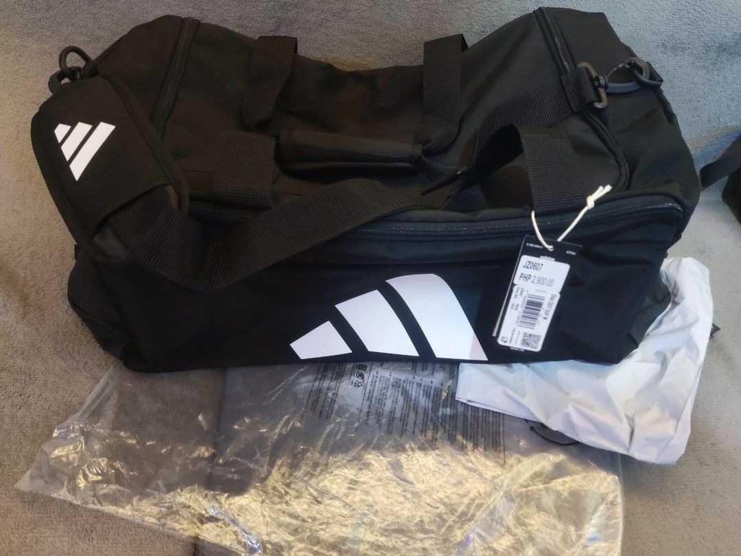 Adidas Training Duffel Bag Medium Black (Category: Sling Bags) located in Navotas City. Submitted by jhurram002 (Listing ID 1468405935, Image 1). Description: - Brand: Adidas - Color: Black with large white logo on the front - Size: Medium training duffel bag - Condition: Brand new with original store tags attached - Features: Sturdy shoulder strap with heavy-duty plastic clip and durable zippers for main compartment and side pocket srp: 2,900 no