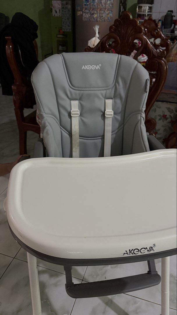 Akeeva Cozzi High Chair (Category: Baby High Chairs) located in Tagaytay City. Submitted by alexaerina (Listing ID 1468298372, Image 2). Description: - Brand/Model: Akeeva Cozzi High Chair - Color: Grey with white tray and grey plastic accents - Height Adjustment: 6 positions for custom feeding levels - Tray: 2-position adjustable white tray - Safety & Comfort: Leatherette seat pad with built-in safety harness - Storage: Sturdy metal frame that f