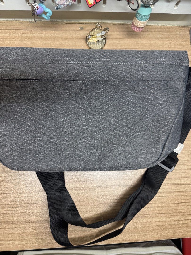 Algspor Grey Crossbody Messenger Bag (Category: Sling Bags) located in Manila. Submitted by xenasales (Listing ID 1468375107, Image 2). Description: - Brand: Algspor - Color: Grey with navy blue lining - Design: Textured geometric pattern on front flap - Strap: Adjustable black nylon strap with buckle - Closure: Secure magnetic snap closure - Interior: Multiple slip and zip pockets for easy organization - Condition: Clean interior, ready for dail