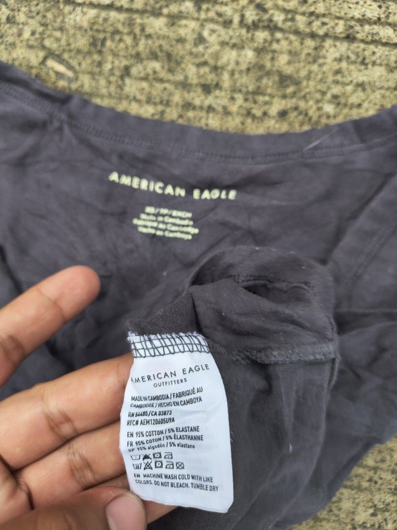 American Eagle Ruched V-Neck Crop Top Dark Grey (Category: Shirts) located in Manila. Submitted by ericksongene.1118 (Listing ID 1468288292, Image 3). Description: - Brand: American Eagle - Size: XS - Color: Dark Grey - Material: 95% Cotton, 5% Elastane (soft & stretchable) - Design: V-neck, chic front ruching, short sleeves - Care: Machine washable in cold water - Condition: Brand new / Excellent.