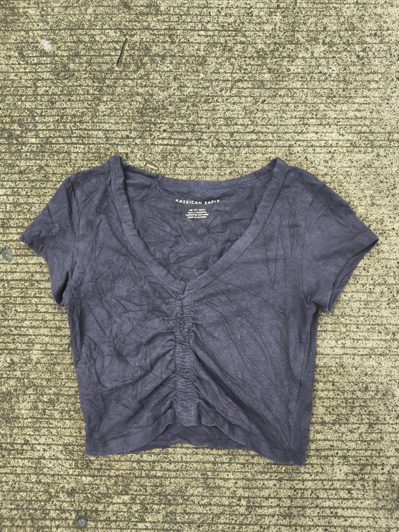 American Eagle Ruched V-Neck Crop Top Dark Grey (Category: Shirts) located in Manila. Submitted by ericksongene.1118 (Listing ID 1468288292, Image 1). Description: - Brand: American Eagle - Size: XS - Color: Dark Grey - Material: 95% Cotton, 5% Elastane (soft & stretchable) - Design: V-neck, chic front ruching, short sleeves - Care: Machine washable in cold water - Condition: Brand new / Excellent.