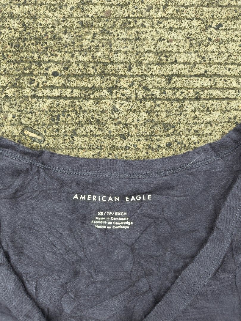 American Eagle Ruched V-Neck Crop Top Dark Grey (Category: Shirts) located in Manila. Submitted by ericksongene.1118 (Listing ID 1468288292, Image 2). Description: - Brand: American Eagle - Size: XS - Color: Dark Grey - Material: 95% Cotton, 5% Elastane (soft & stretchable) - Design: V-neck, chic front ruching, short sleeves - Care: Machine washable in cold water - Condition: Brand new / Excellent.