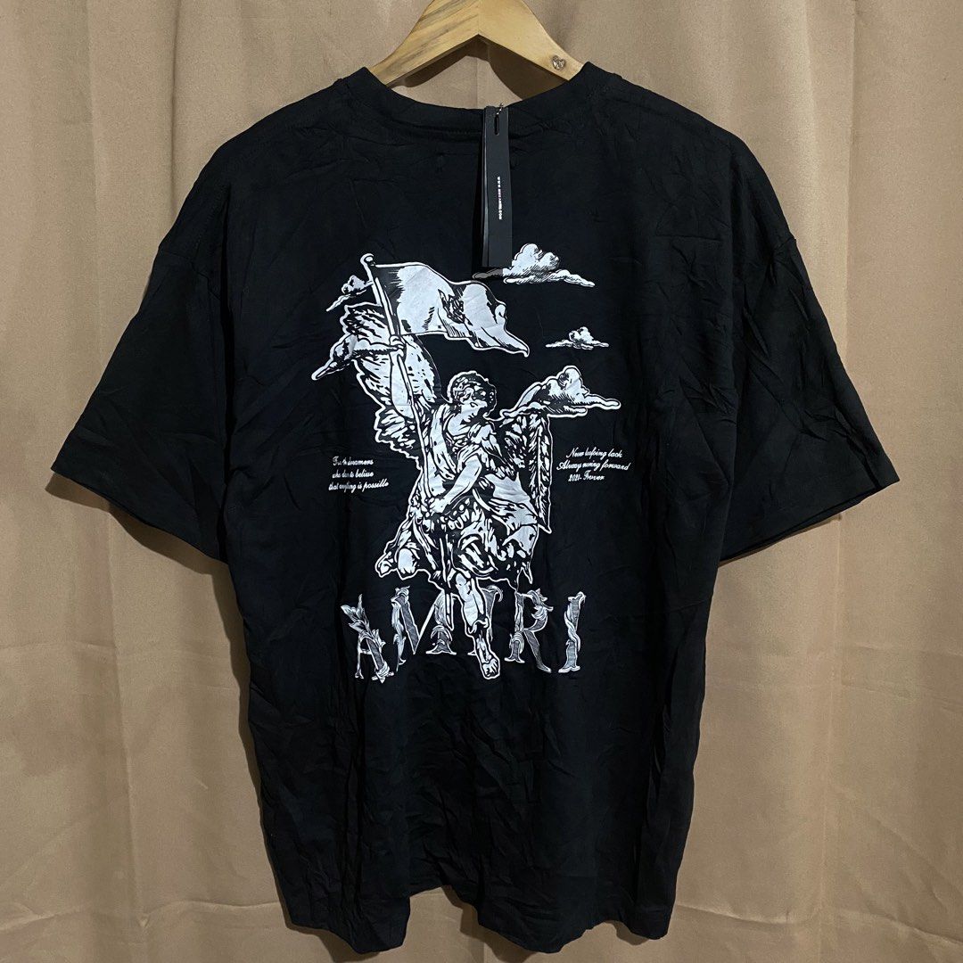 AMIRI Black Angel Flag Print Tee (Category: Tshirts & Polo Shirts ) located in Manila. Submitted by why_notph (Listing ID 1468422678, Image 1). Description: - Brand: Amiri - Color: Classic Black - Design: Large angel with flag graphic, cloud details, and bold Amiri branding on the back - Inclusions: Original neck label and hanging hangtag with ball chain - Condition: Brand new with tags - Meet-ups or shipping available nationwide via J&T/Flash - 