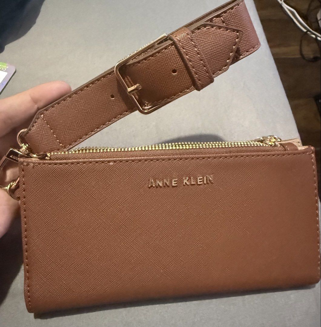 Anne Klein Brown Wristlet Wallet (Category: Wallets & Card holders) located in Cainta. Submitted by mykee1 (Listing ID 1468372578, Image 2). Description: - Brand: Anne Klein - Material: Premium brown textured faux leather with elegant gold hardware - Closure: Secure top zip closure - Features: Includes a matching wrist strap with adjustable buckle detail - Size: Compact and handy, fits easily in your hand or larger everyday bag - Condition: Brand